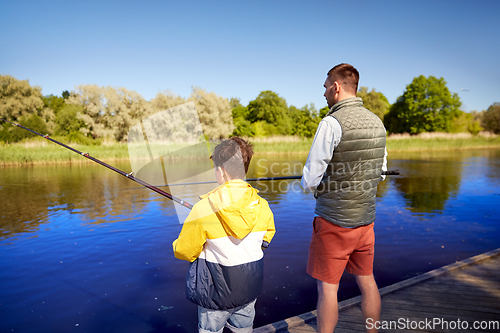 Image of father and son fishing on river