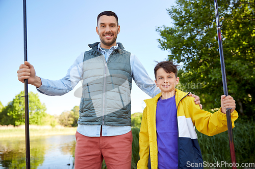 Image of happy smiling father and son fishing on river