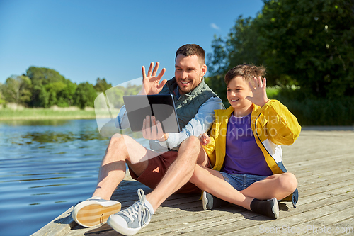 Image of father and son with tablet pc having video call