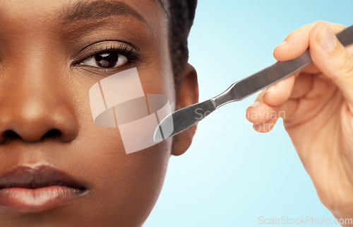 Image of face of african american woman and scalpel knife