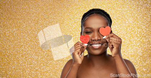 Image of smiling african american woman with red hearts