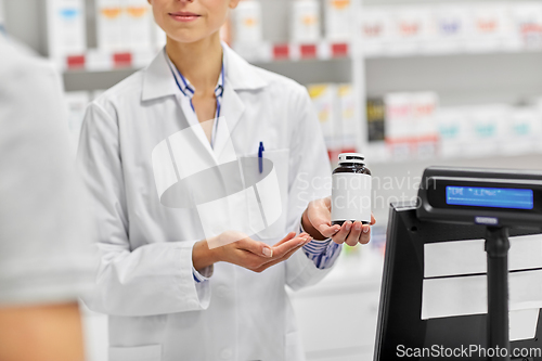 Image of pharmacist and customer with medicine at pharmacy