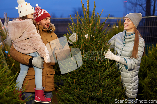 Image of happy family choosing christmas tree at market