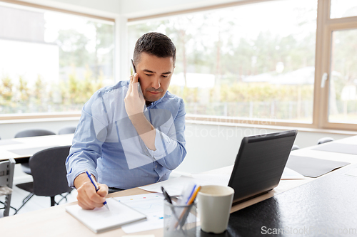 Image of man calling on smartphone at home office