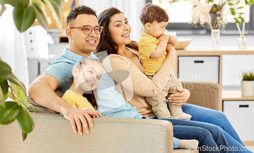 Image of portrait of happy family sitting on sofa at home