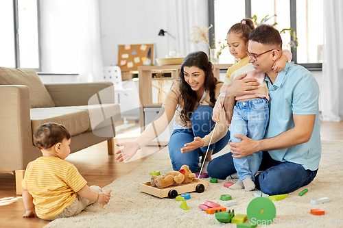 Image of happy family palying with wooden toys at home