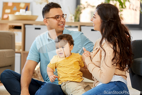 Image of happy family with child sitting on sofa at home
