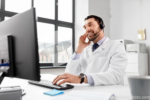 Image of happy doctor with computer and headset at hospital