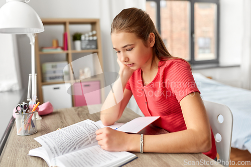 Image of student teenage girl reading book at home
