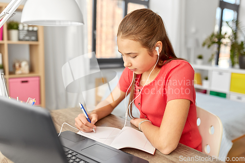 Image of student girl in earphones learning at home