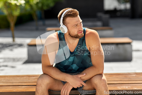 Image of man in headphones listening to music outdoors