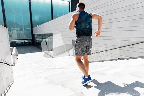 Image of young man in headphones running downstairs