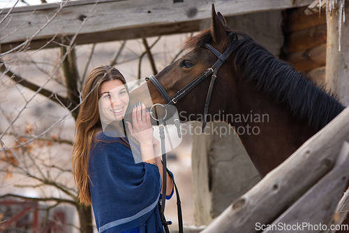 Image of Portrait of a happy girl hugging a horse, the girl joyfully looks into the frame