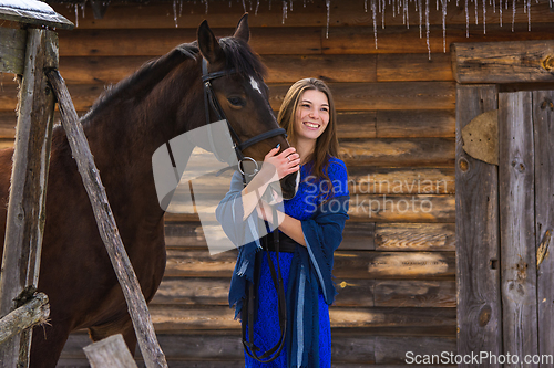 Image of Happy girl hugging a horse and looking into the distance