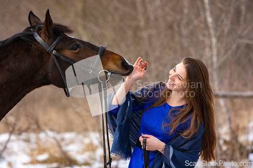 Image of Happy girl playing with horse, horse shows teeth, closeup portrait