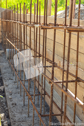 Image of Construction of a strip foundation, reinforcement strapping, formwork in the background