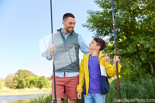 Image of happy smiling father and son fishing on river