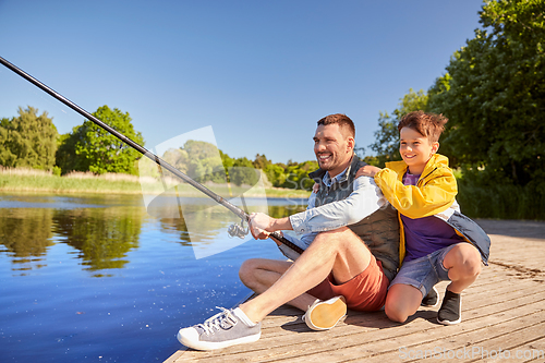 Image of happy smiling father and son fishing on river