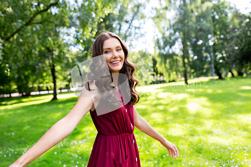 Image of portrait of happy smiling woman at summer park