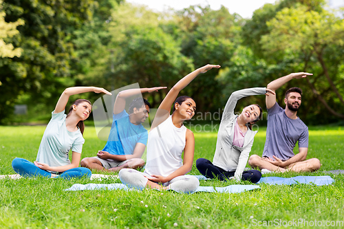 Image of group of people exercising at summer park