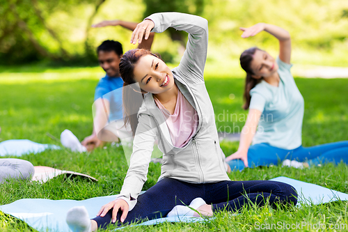 Image of group of people exercising at summer park