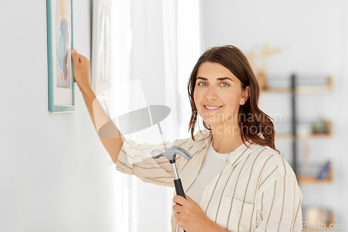 Image of woman decorating home with picture in frame
