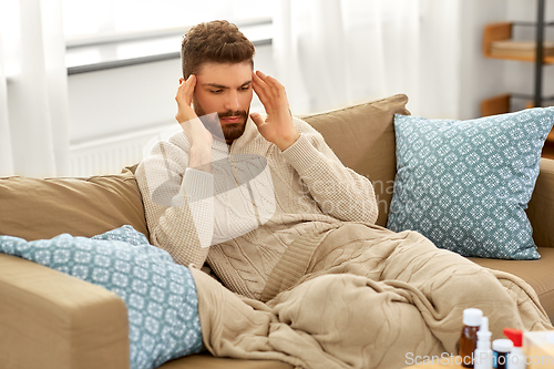 Image of unhappy man suffering from head ache at home