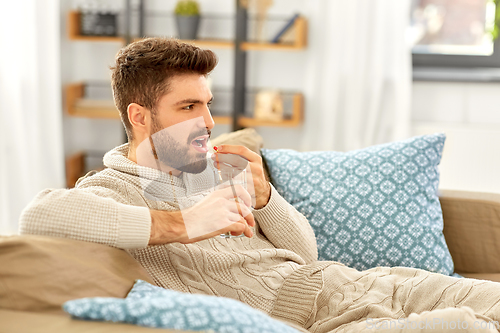 Image of sick man with glass of water and medicine at home