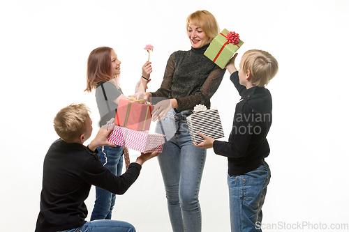 Image of Children give a gift to mom, boys give a gift in boxes, flower girl