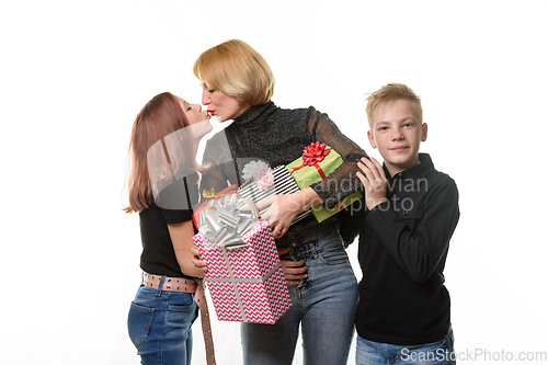 Image of Children congratulated mom on her birthday and gave gifts, mom kisses her daughter as a token of gratitude