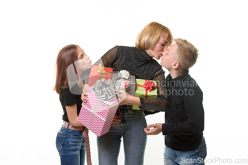 Image of Children congratulated mom on her birthday and gave gifts, mom kisses her son as a token of gratitude