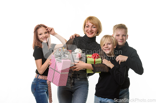 Image of Children congratulated their mother on her birthday, look into the frame together and smile