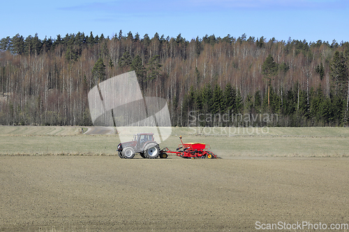 Image of Rural Landscape with Tractor and Seed Drill in Field