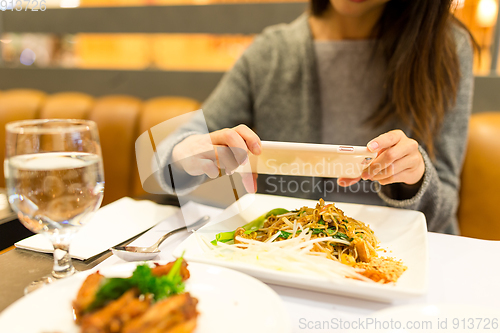Image of Woman taking photo on her dinner