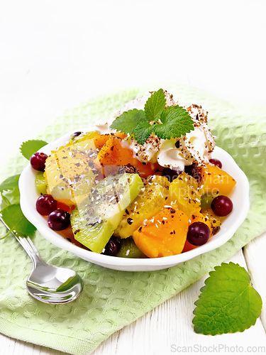 Image of Salad fruit with cranberries in bowl on wooden board