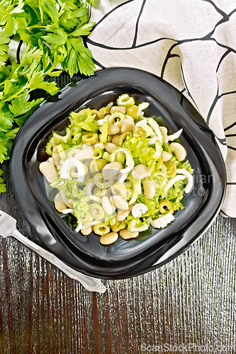 Image of Salad of beans and olives in plate on dark board top