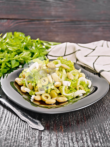 Image of Salad of beans and olives in plate on wooden board