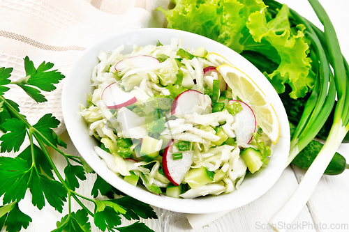 Image of Salad of cabbage with radish in plate on light board