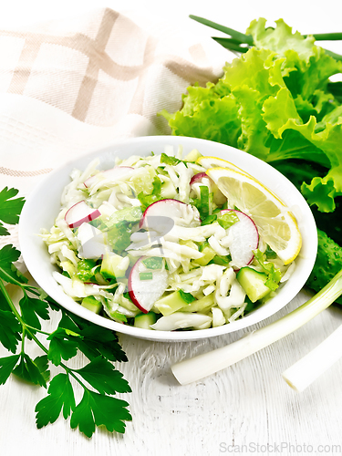 Image of Salad of cabbage with radish in plate on table