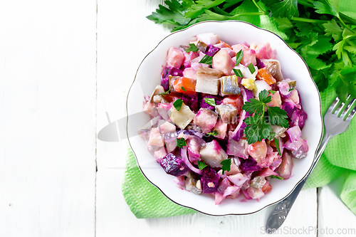 Image of Salad with herring and beetroot in bowl on napkin top