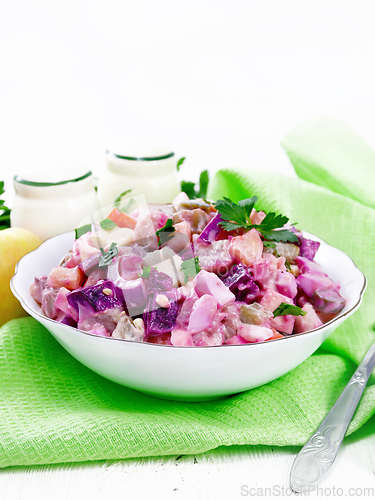 Image of Salad with herring and beetroot in bowl on towel