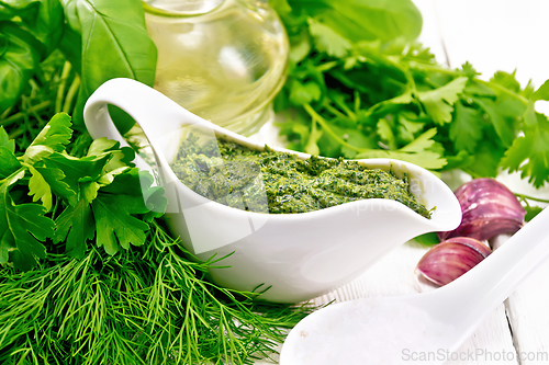 Image of Sauce of spicy greens in gravy boat on board