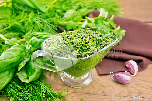 Image of Sauce of spicy greens in gravy boat on old wooden board