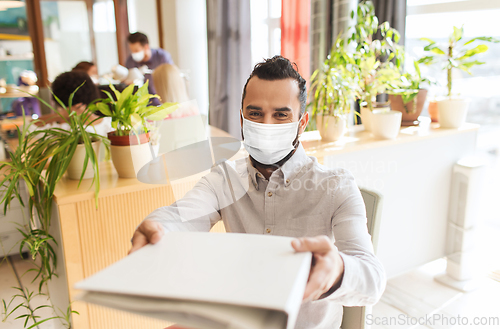 Image of creative male office worker in mask with folder