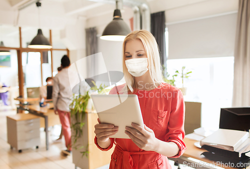 Image of female office worker in mask with tablet pc