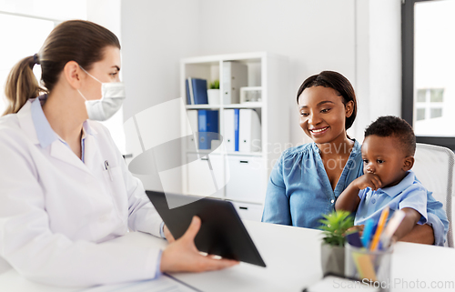 Image of mother, baby and doctor in mask with tablet pc