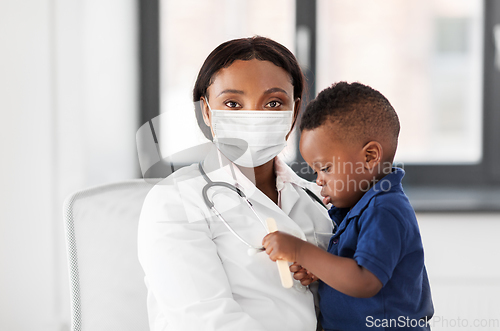 Image of doctor in mask with baby patient at clinic