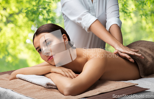 Image of woman lying and having back massage at spa