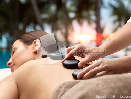 Image of close up of woman having hot stone massage at spa