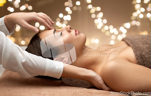 Image of woman having face and head massage at spa